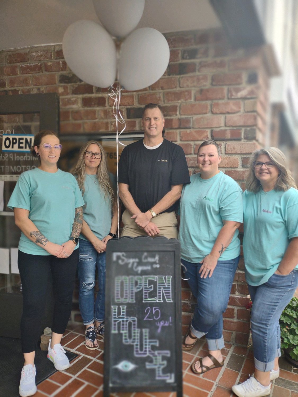 Dr. Michael P. Scheidler, center, poses with members of his office staff, from left, Heather Heckman, Mirah Merschon, Alissa Nicoson and Melissa Stribling during an open house celebrating his 25 years in business at 109 E. Main St.